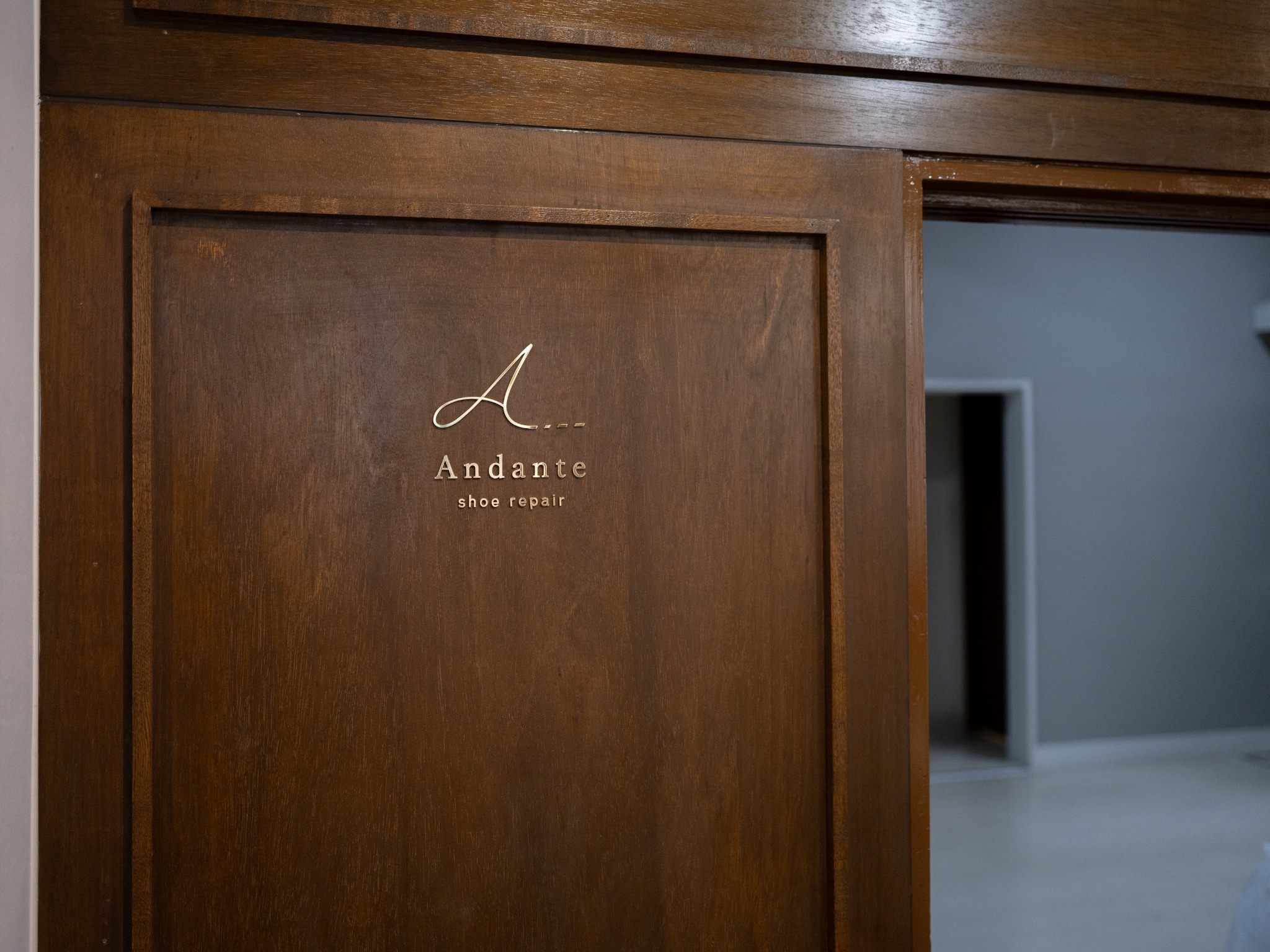 Andante shoe repair の玄関ドアにある店名サイン